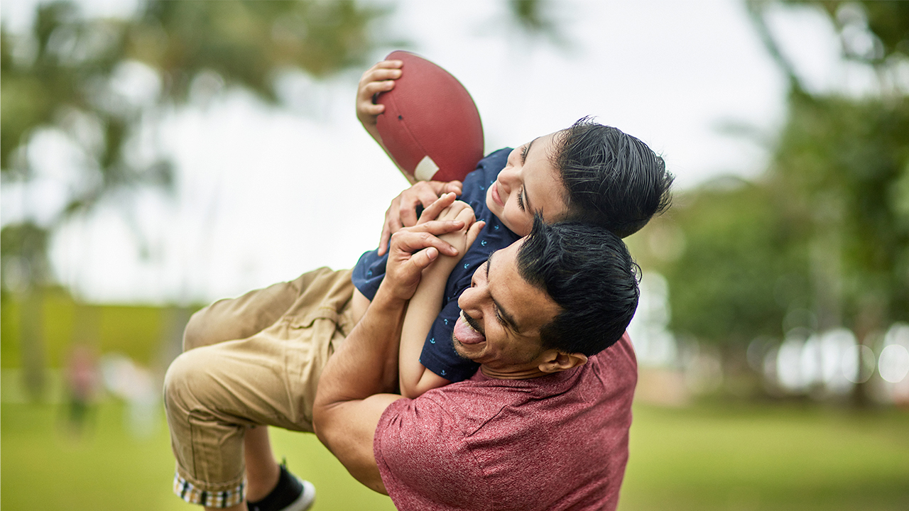 Dad and son playing football