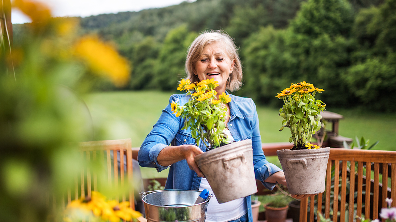 Middle-aged woman holding flowerpots