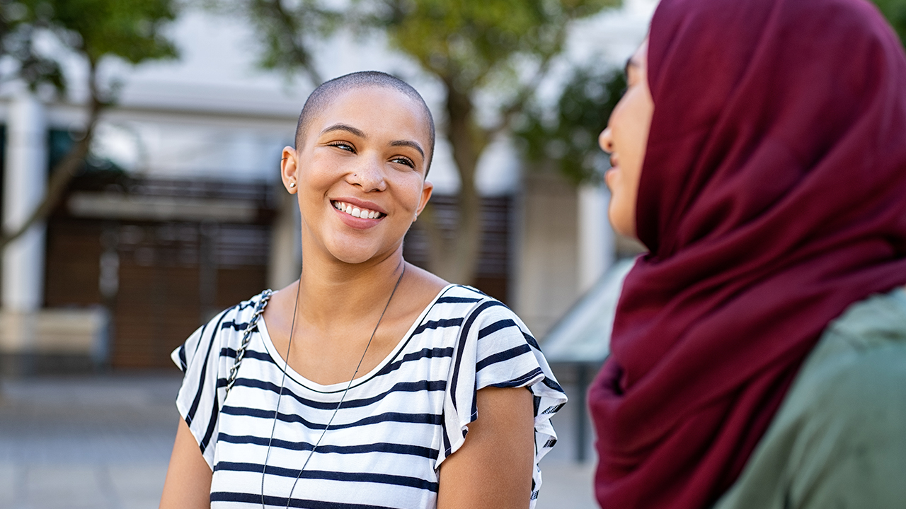 Two young women smiling and talking